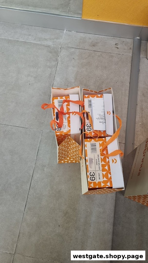 Sunnystep shoe boxes with orange ribbons and product labels on a tiled floor.