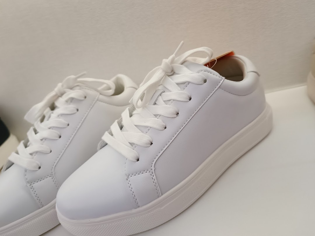Close-up of a pair of pristine white sneakers displayed at Sunnystep.