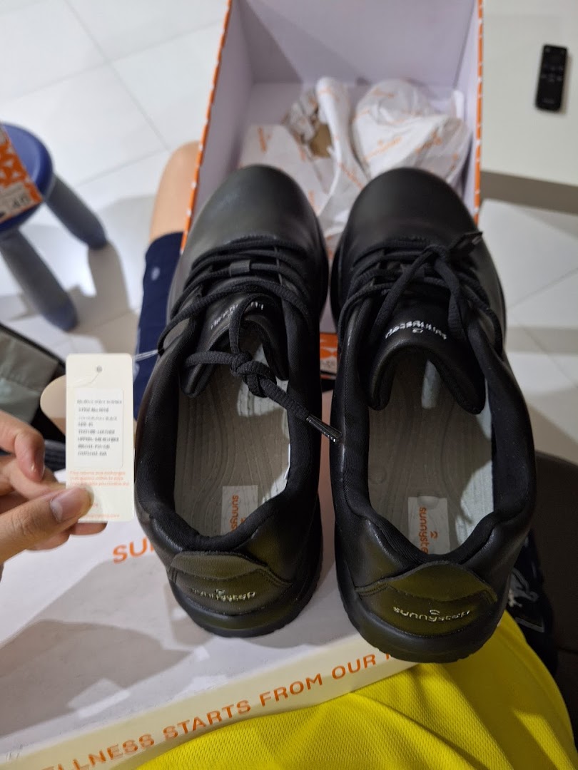 A pair of new black Sunnystep shoes displayed in their box, with a product tag visible.