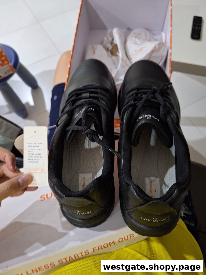 A pair of new black Sunnystep shoes displayed in their box, with a product tag visible.