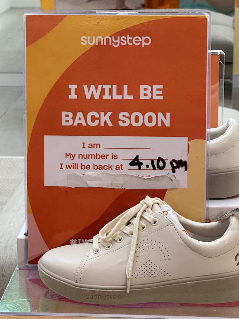 A Sunnystep sign indicating 'I will be back soon' at 4:10 PM, with a white shoe in the foreground.