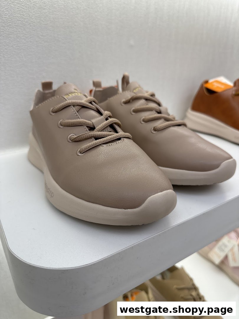 A close-up of a pair of stylish beige Sunnystep shoes displayed on a white shelf.
