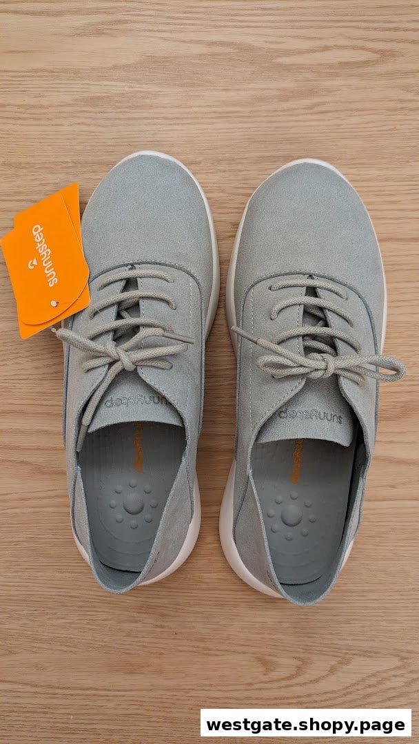 A pair of light grey Sunnystep shoes with tags displayed on a wooden surface.