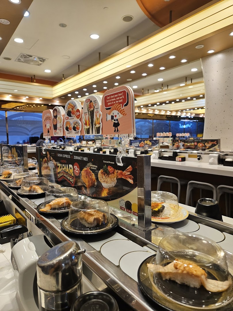 A vibrant interior shot of Sushi Express, showcasing its conveyor belt laden with fresh sushi plates.