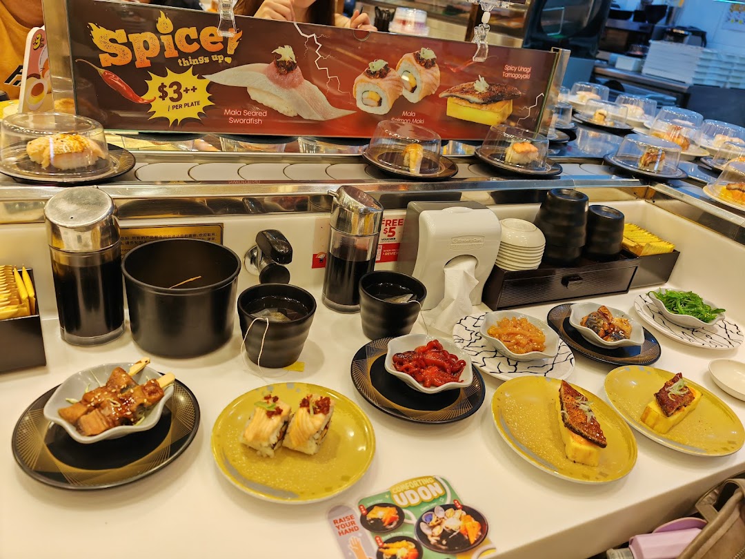A vibrant sushi conveyor belt at Sushi Express, featuring diverse dishes and a promotional sign.