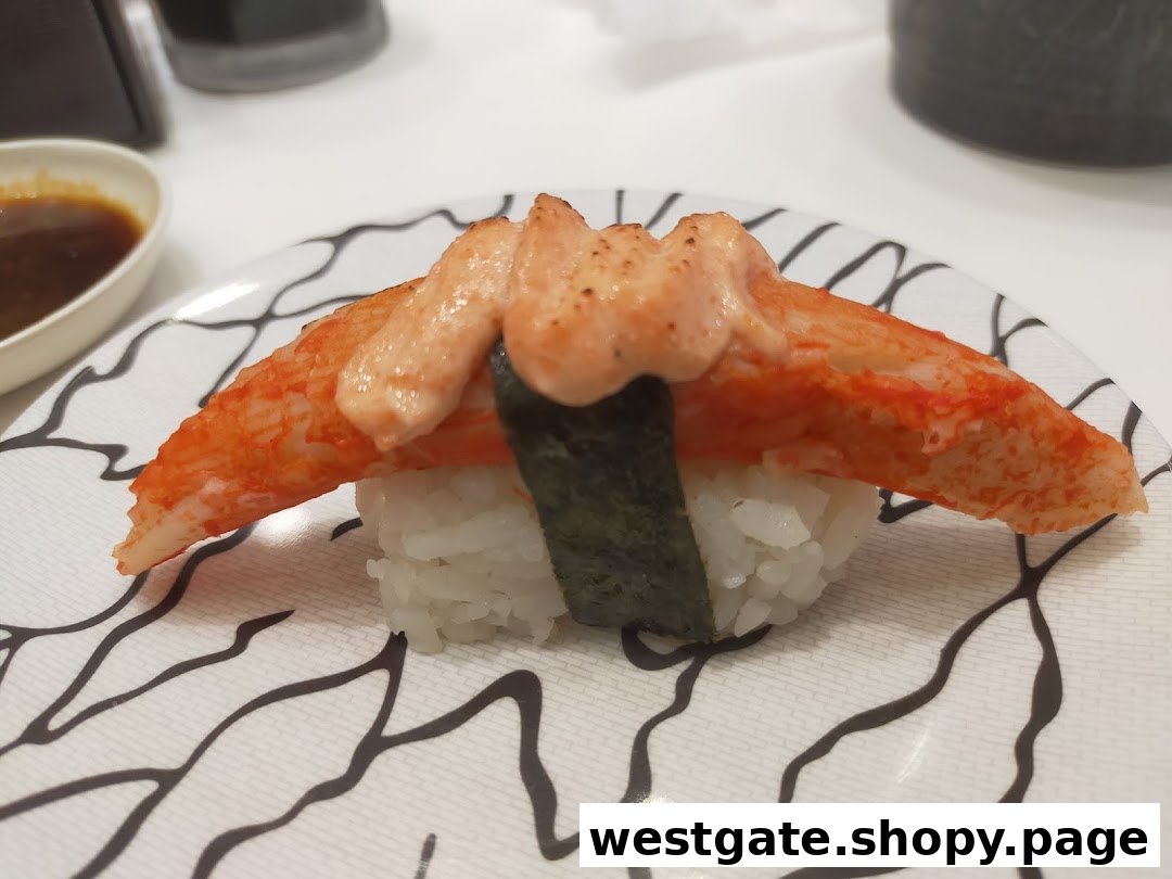 A close-up of a delicious crab stick sushi topped with creamy sauce on a patterned plate.