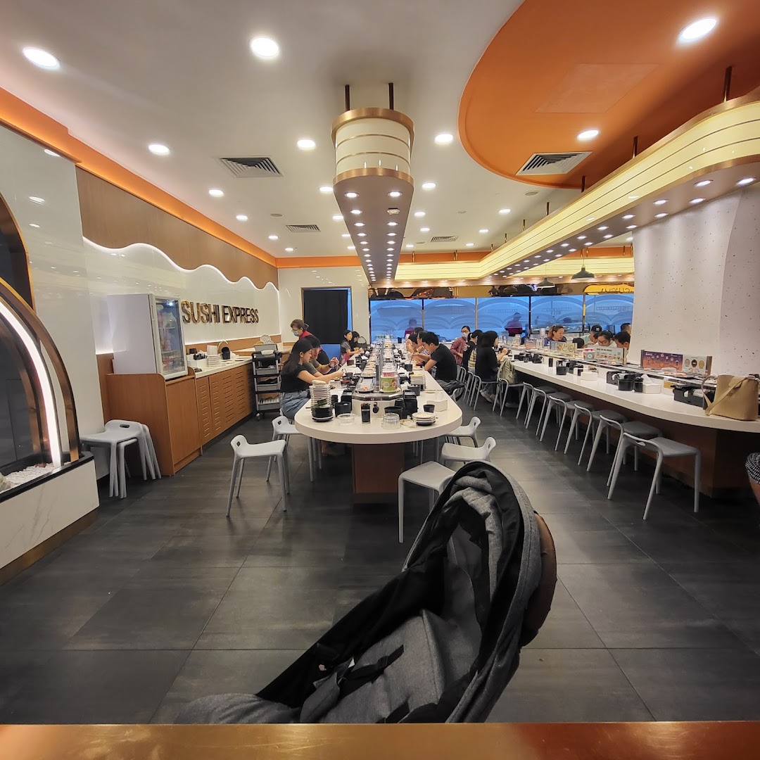 Vibrant interior of Sushi Express with customers enjoying conveyor belt sushi and a modern dining experience.