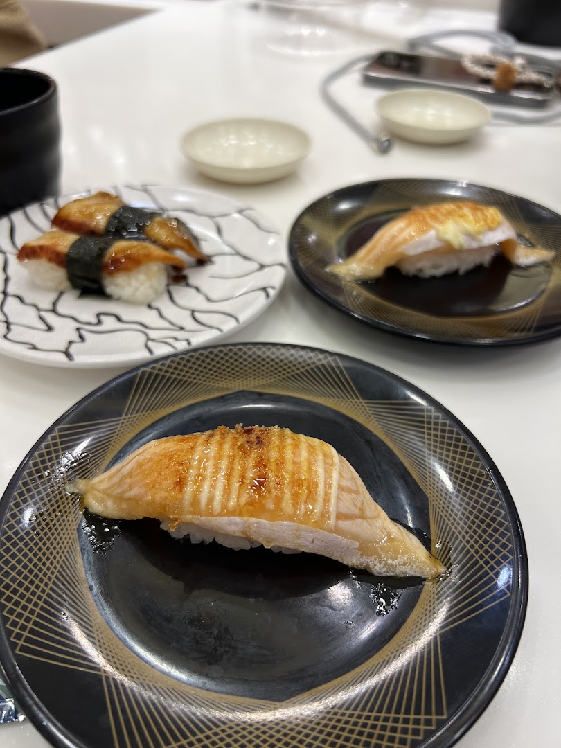 Close-up of delicious sushi dishes, including unagi and torched salmon, served on plates.