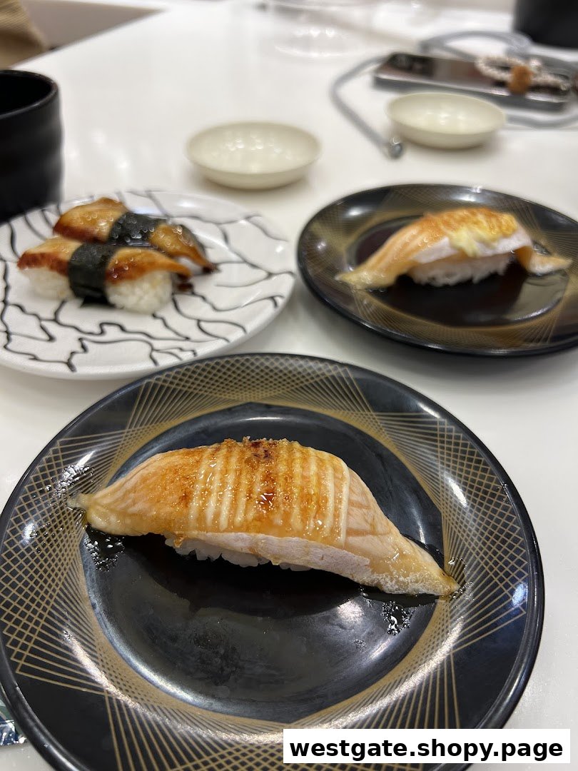 Close-up of delicious sushi dishes, including unagi and torched salmon, served on plates.