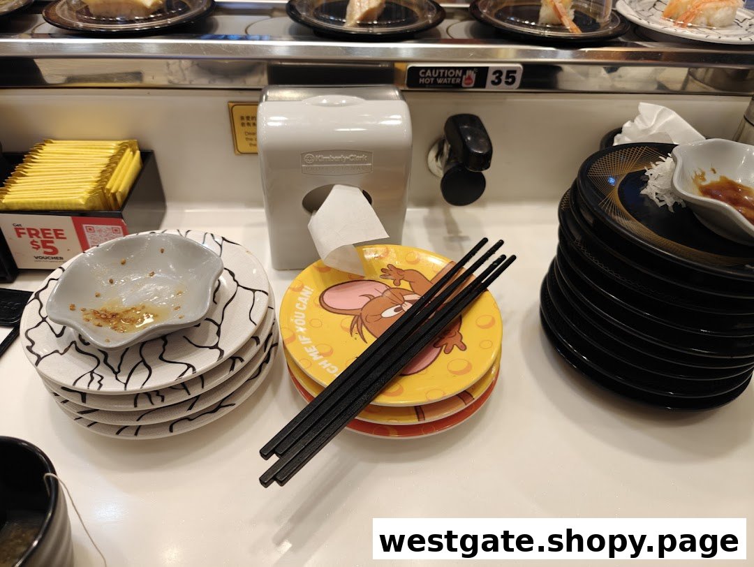 A close-up of a sushi conveyor belt dining area with plates, chopsticks, and a hot water tap.