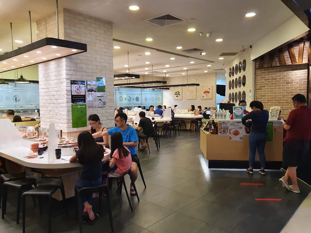 Interior of Sushi Express, showing customers enjoying conveyor belt sushi and a lively dining atmosphere.