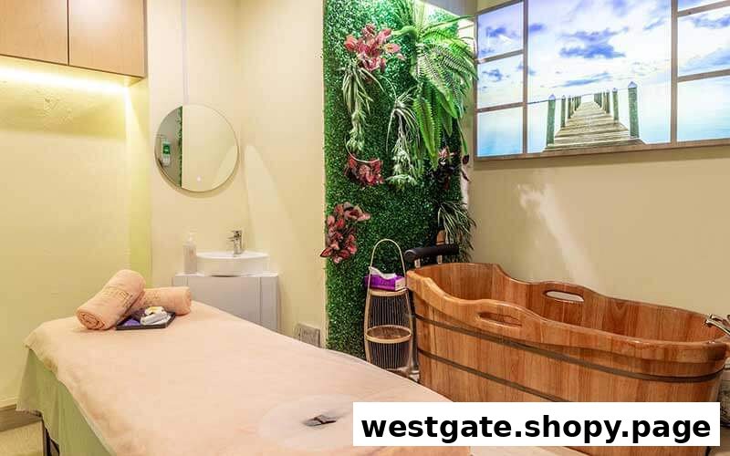 A serene spa room featuring a massage bed, wooden bath tub, green wall, and scenic window art.