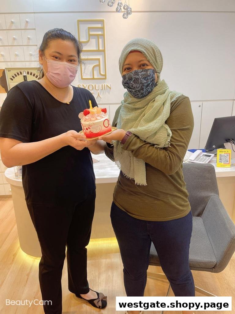 Two masked women celebrate with a small cake inside the Syoujin shop.