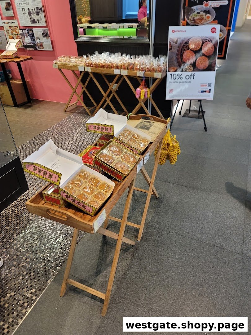 A shop entrance displaying mooncakes and other traditional pastries on wooden stands, with a promotional sign.
