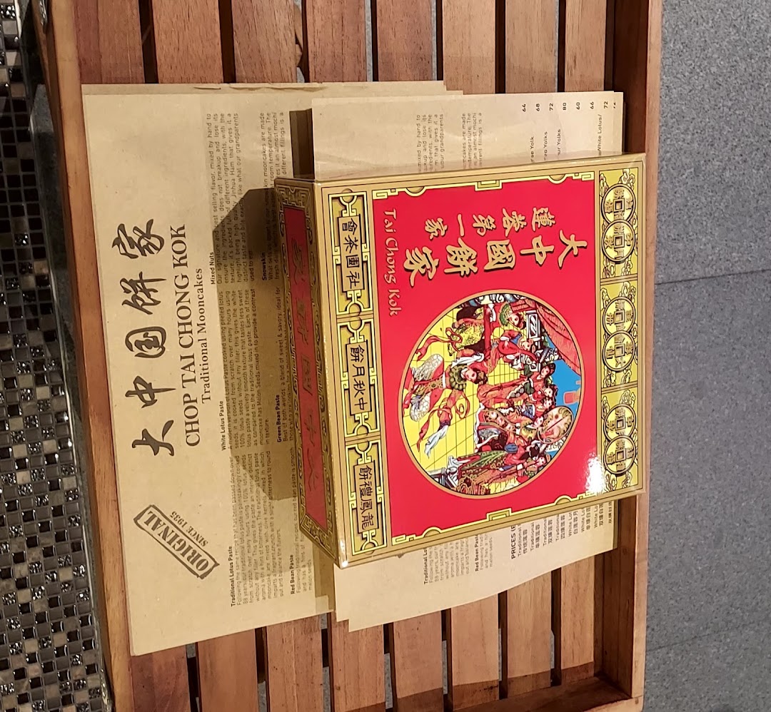 A display of traditional mooncake boxes and a brochure detailing various mooncake flavors and prices.