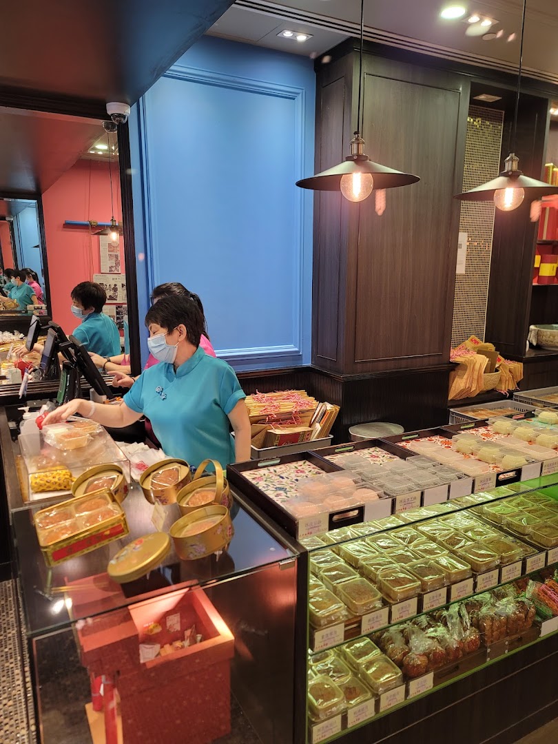 A staff member serves customers at Tai Chong Kok, showcasing a variety of traditional Chinese pastries and snacks.