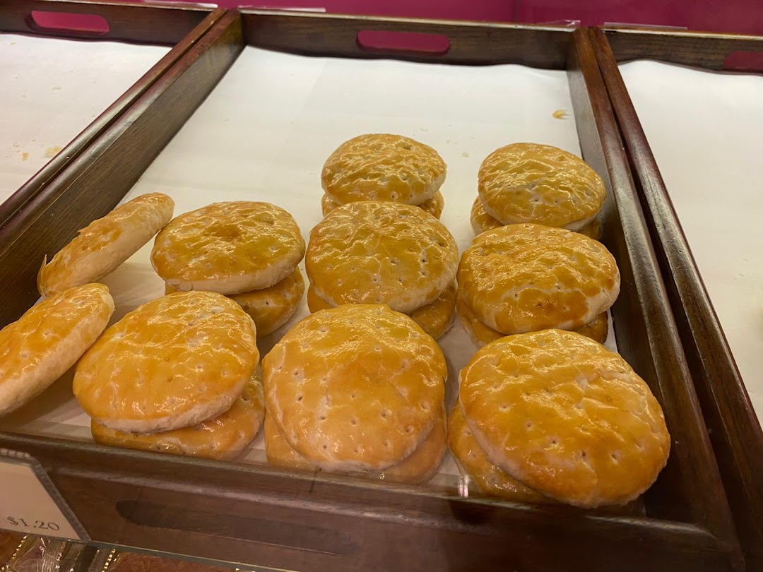 Golden-brown traditional Chinese pastries, possibly tau sar piah, displayed in wooden trays at Tai Chong Kok.