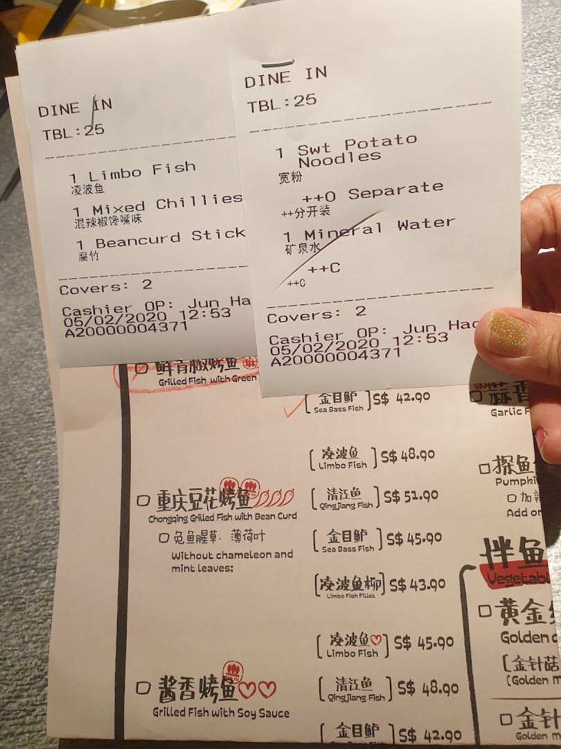 A close-up view of TANYU's menu and customer receipts, showcasing popular grilled fish options and add-ons.