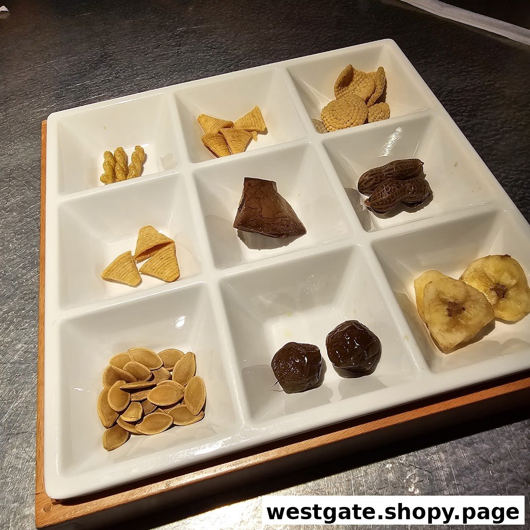A white nine-compartment tray filled with various snacks like nuts, dried fruits, and crispy bites.