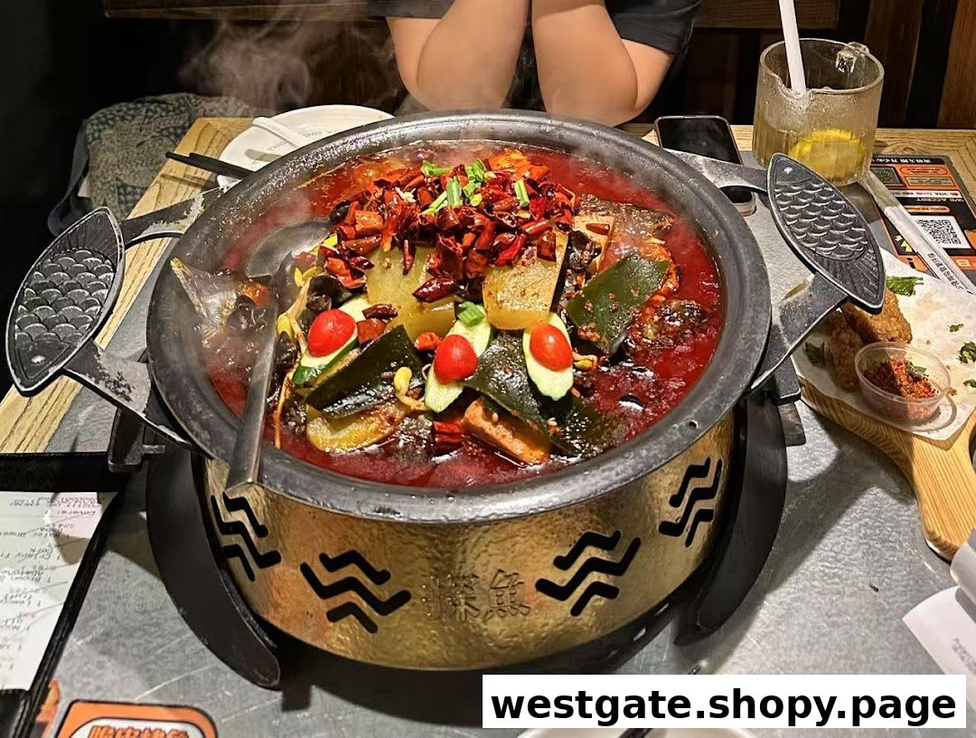 A steaming pot of spicy grilled fish with vegetables and chili, served on a table at TANYU Westgate.