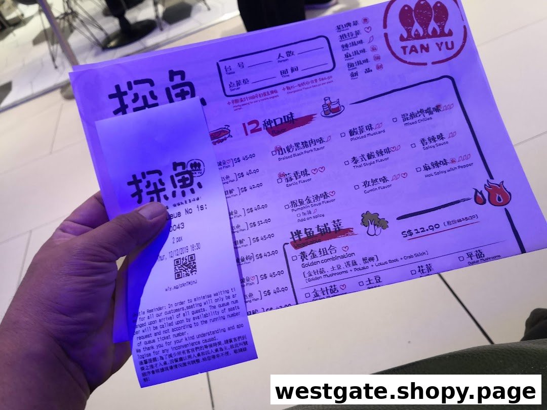 A hand holding a TANYU menu and queue ticket with various fish flavors and side dishes.