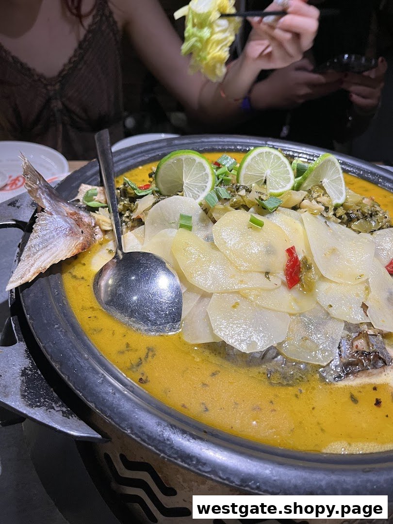 A large pot of TANYU's signature grilled fish with lime and potatoes, served hot at the table.