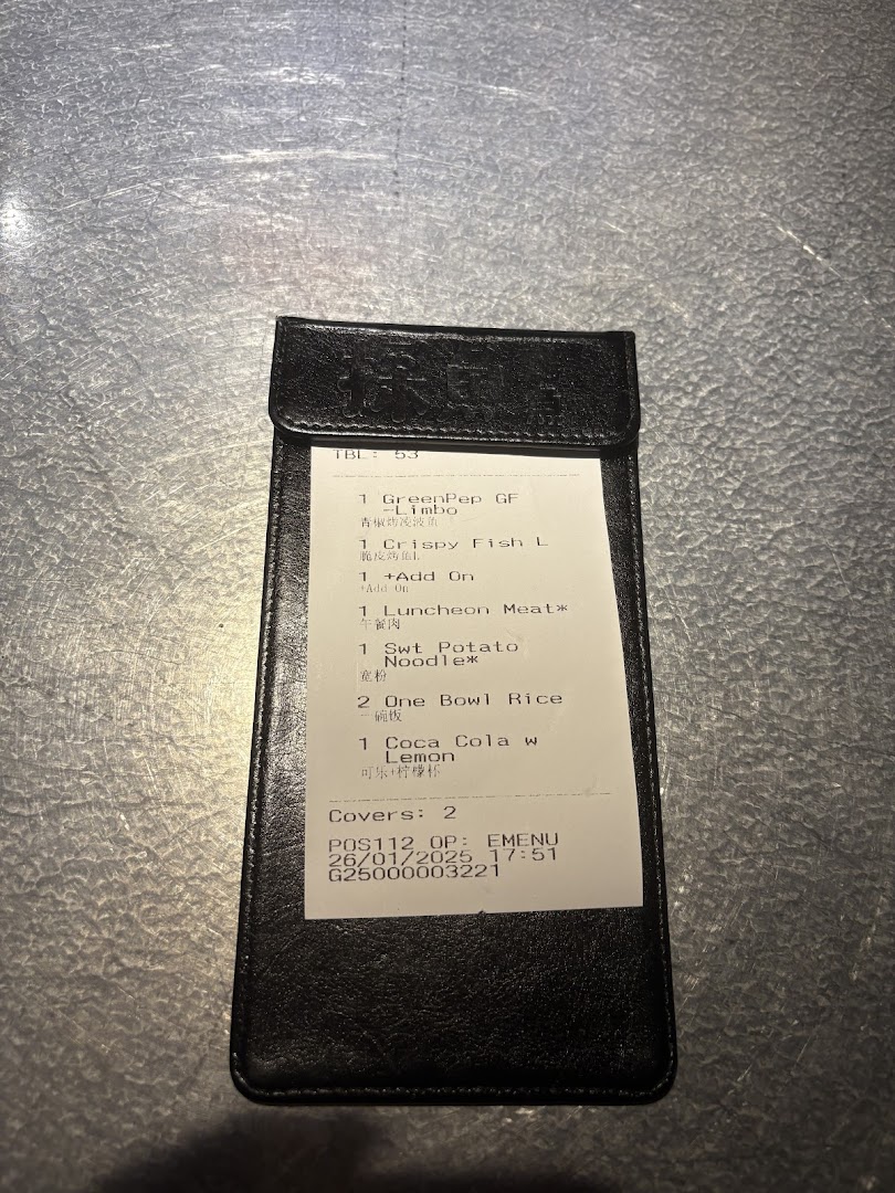 A close-up of a TANYU Westgate order slip inside a black billfold, showing ordered food items.