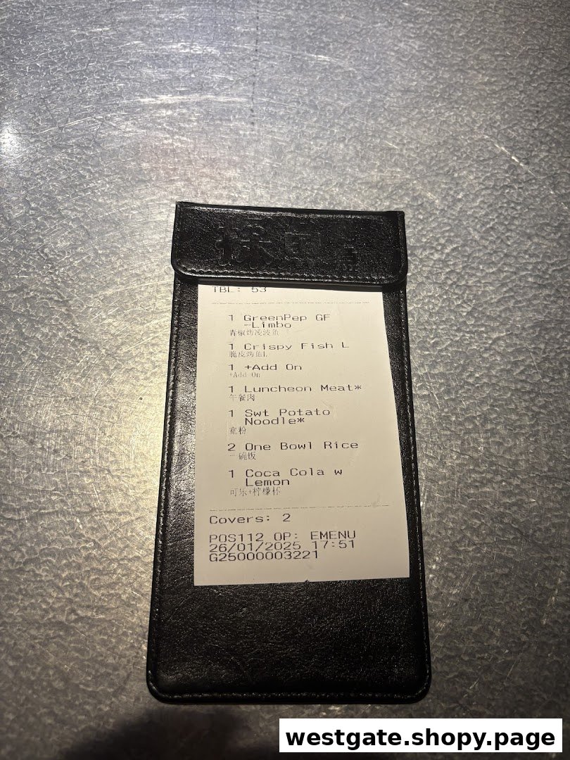 A close-up of a TANYU Westgate order slip inside a black billfold, showing ordered food items.