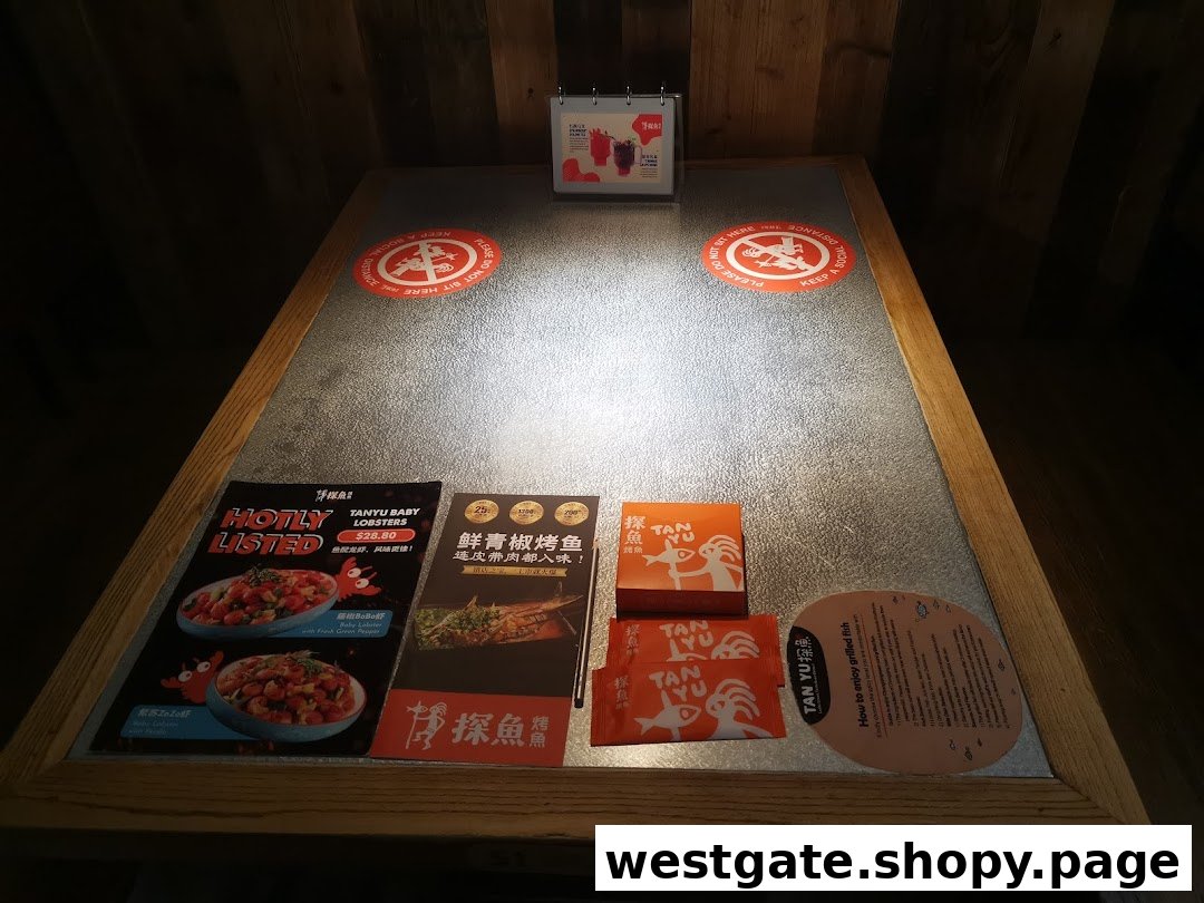 A restaurant table at TANYU Westgate featuring menus, branding, and social distancing reminders.