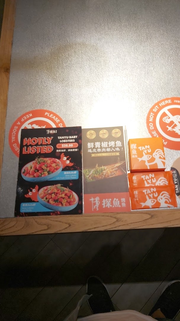 Promotional flyers and branded boxes for TANYU, featuring lobsters and grilled fish.
