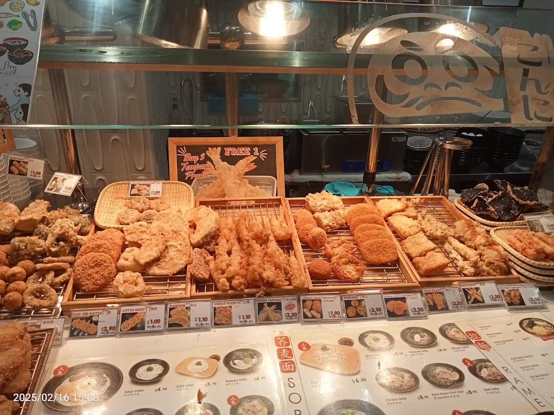 A vibrant display counter showcasing a wide variety of freshly fried tempura and Japanese delights.