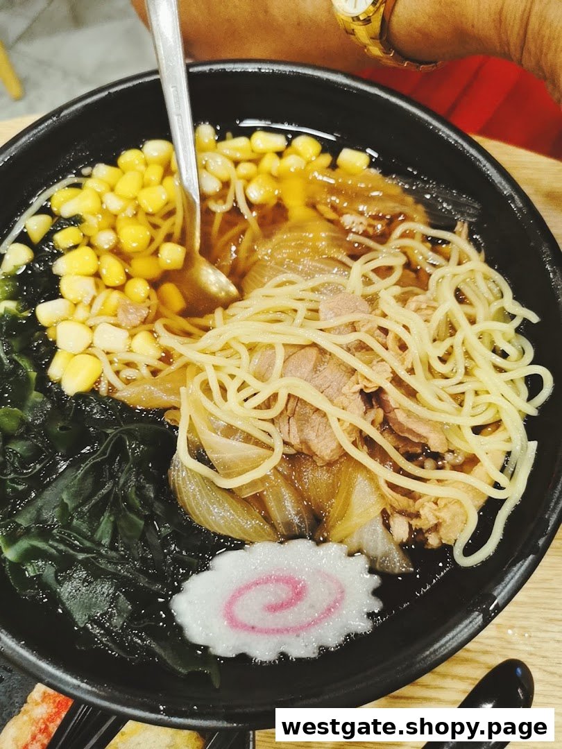A close-up of a delicious bowl of ramen with noodles, corn, seaweed, meat, and a fish cake.