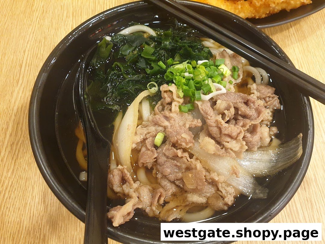 A close-up of a delicious bowl of Japanese udon noodles with beef, seaweed, and green onions.
