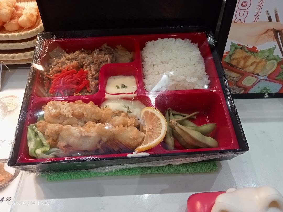 A beautifully presented bento box featuring tempura, rice, and various Japanese side dishes.