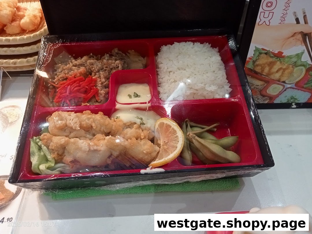 A beautifully presented bento box featuring tempura, rice, and various Japanese side dishes.