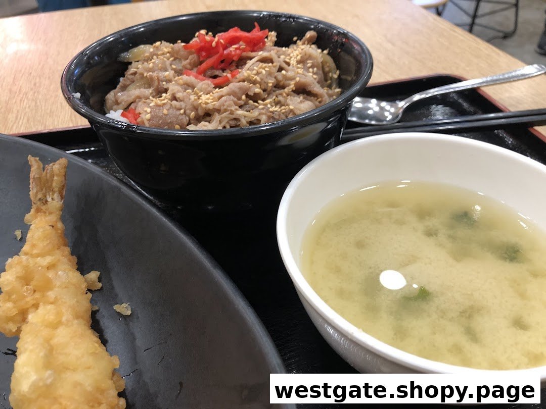 A delicious Japanese meal featuring a beef bowl, crispy tempura, and a comforting bowl of miso soup.
