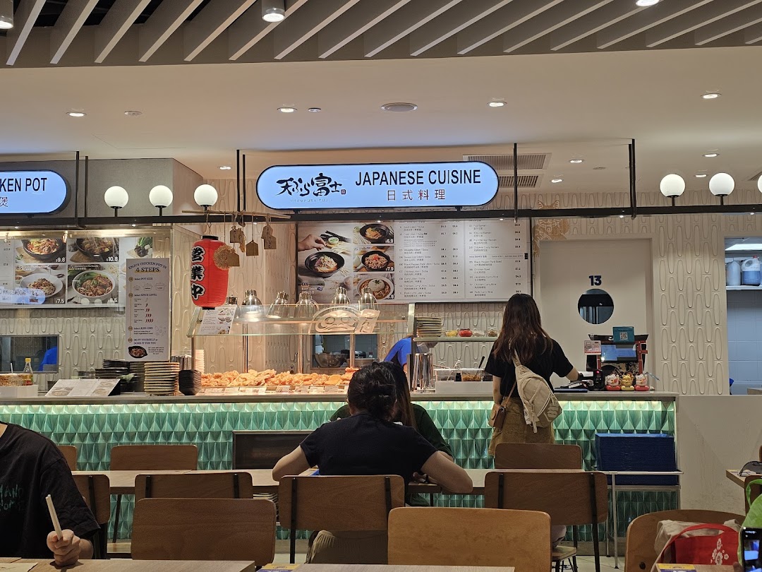 An interior view of Tempura Fuji, a Japanese cuisine stall, with customers and a food display.