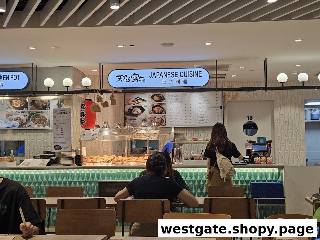 An interior view of Tempura Fuji, a Japanese cuisine stall, with customers and a food display.