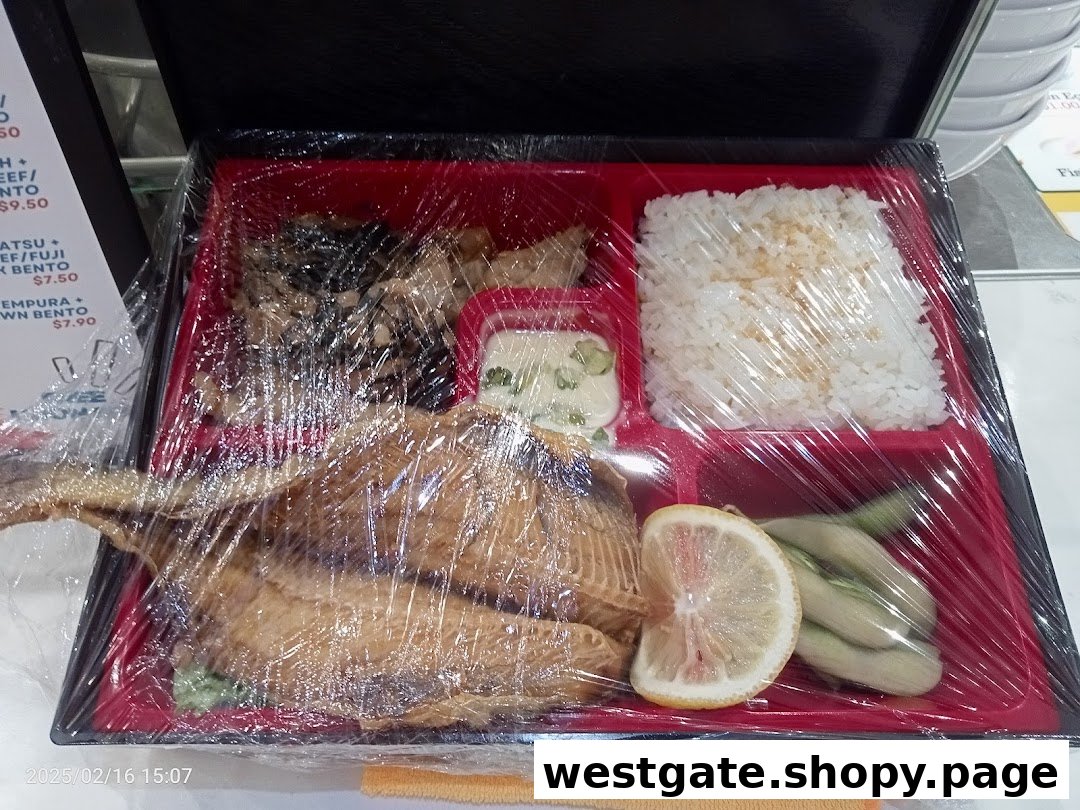 A plastic-wrapped bento box featuring a whole fish, rice, and various side dishes.