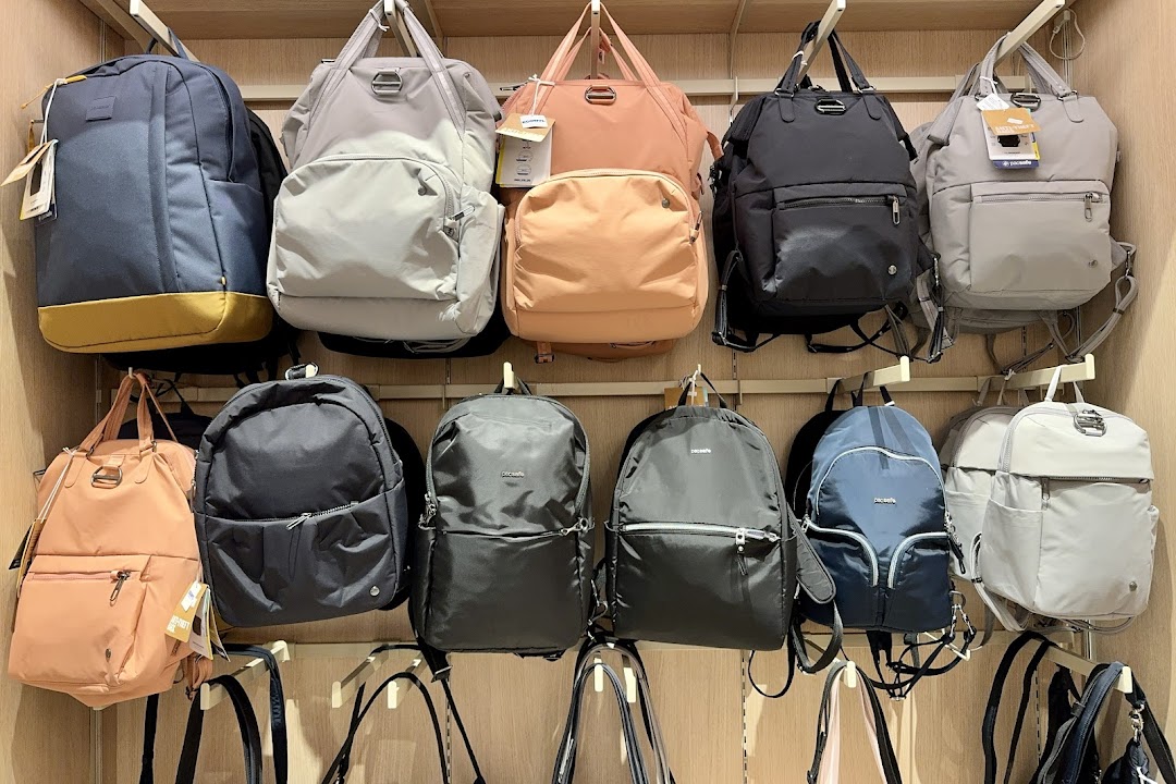 A wall display showcasing a variety of stylish backpacks and bags in different colors and sizes.