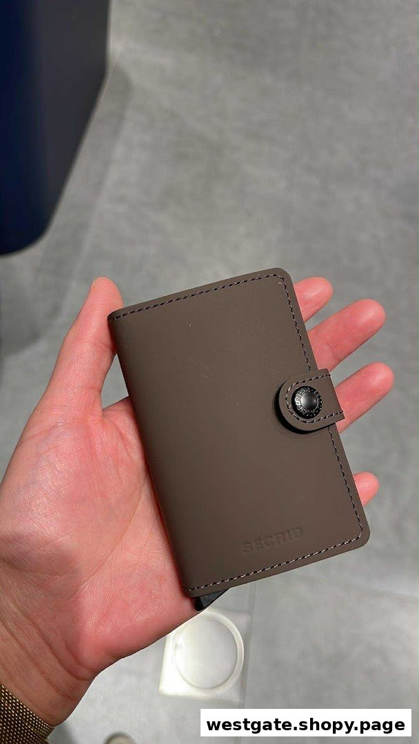 A hand holding a brown Secrid wallet, showcasing its design and texture.