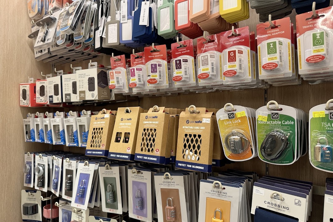 A wall display showcasing various travel accessories including adapters, locks, and luggage tags.