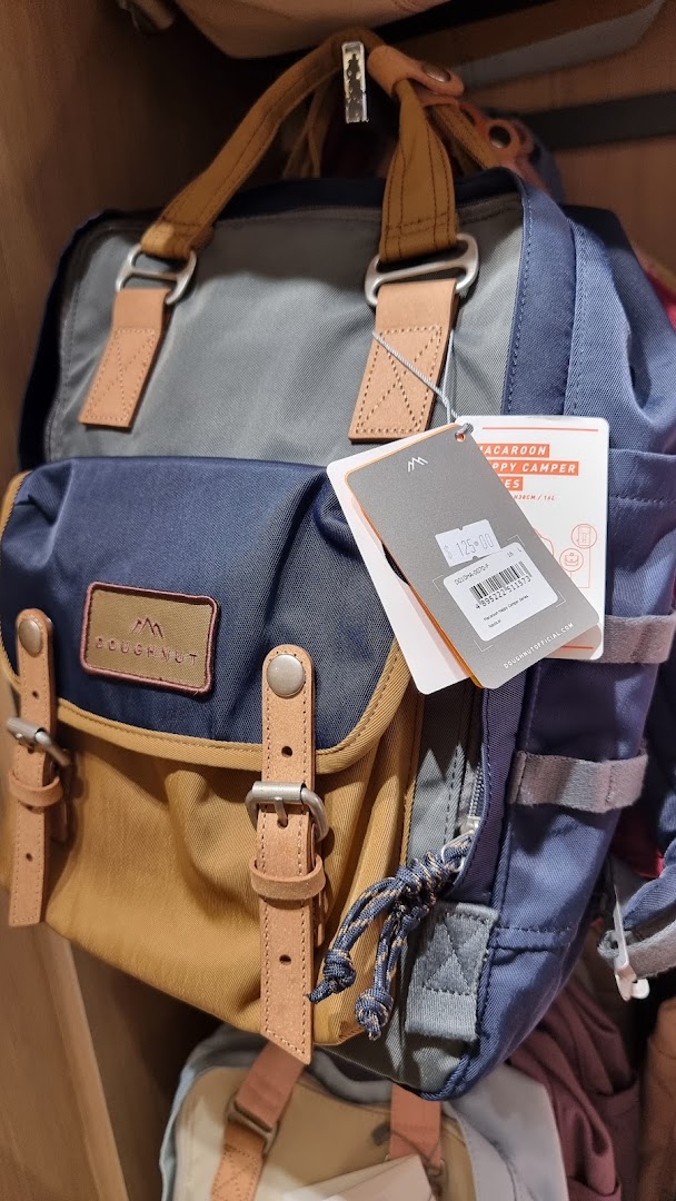 A stylish multi-colored Doughnut brand backpack with a price tag displayed in a retail setting.