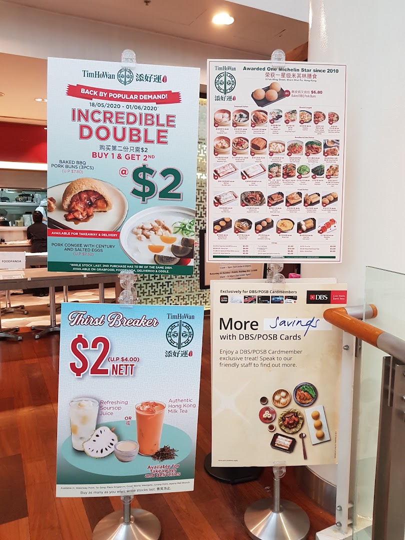 A detailed menu board and promotional posters for Tim Ho Wan, featuring dim sum, drinks, and special offers.