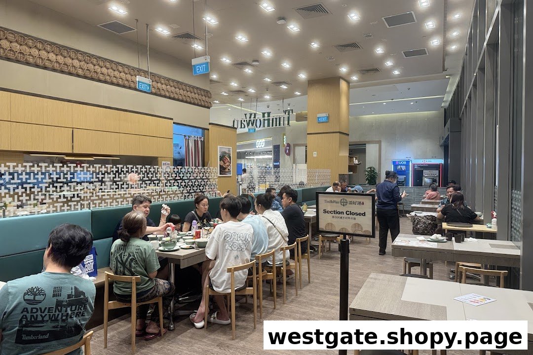Diners enjoying a meal inside the bustling Tim Ho Wan restaurant, featuring a modern interior.
