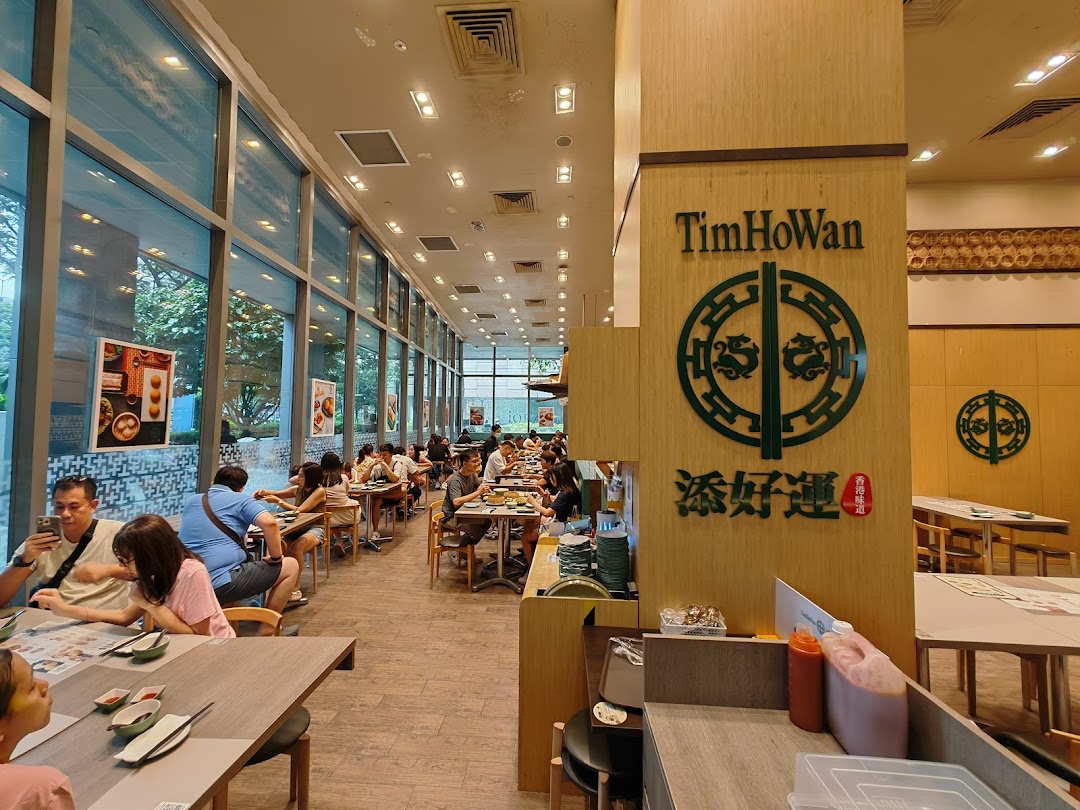 Diners enjoy authentic dim sum in the spacious, brightly lit interior of Tim Ho Wan restaurant.