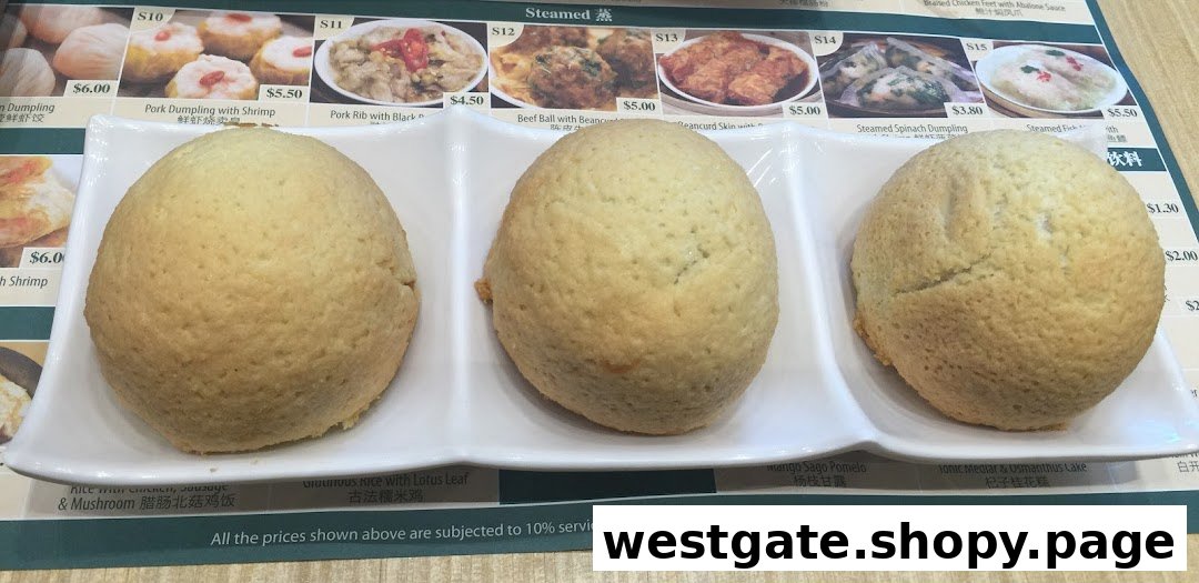 Three baked buns on a white plate with a dim sum menu board in the background.