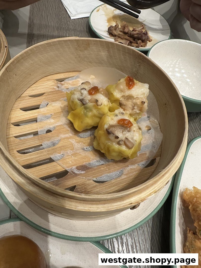 A bamboo steamer basket filled with delicious dim sum, likely siew mai, on a table.