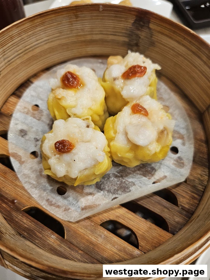 Close-up of four delicious dim sum (siew mai) in a traditional bamboo steamer, ready to be enjoyed.