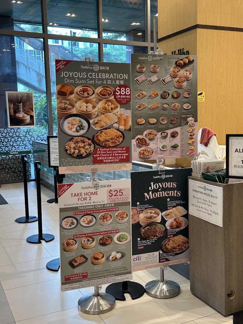 Promotional posters and menus for Tim Ho Wan, featuring dim sum sets and takeaway offers at the shop entrance.